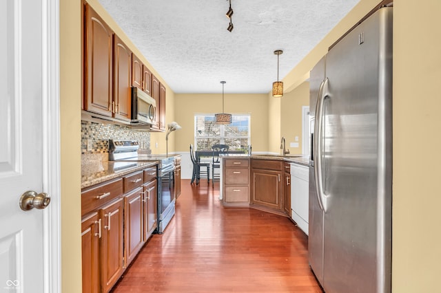 15329 Smithfield Dr, Westfield, IN 46074 - kitchen featuring backsplash, dark wood-style flooring, a textured ceiling, appliances with stainless steel finishes, and brown cabinets