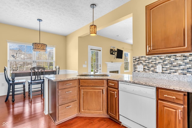 15329 Smithfield Dr, Westfield, IN 46074 - kitchen featuring a sink, dishwasher, a textured ceiling, wood finished floors, and a wealth of natural light