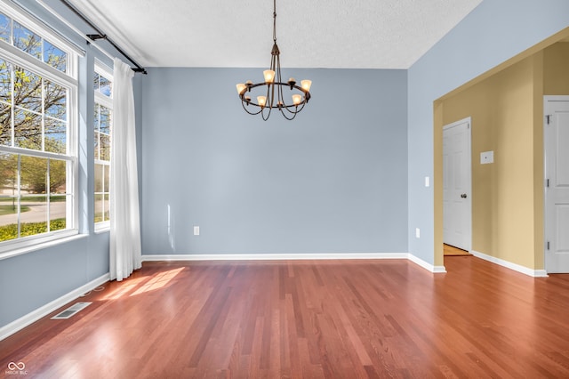15329 Smithfield Dr, Westfield, IN 46074 - spare room featuring a textured ceiling, a chandelier, a wealth of natural light, and wood finished floors