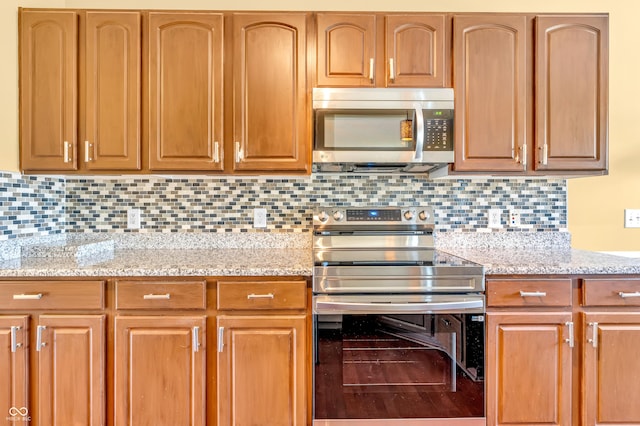 15329 Smithfield Dr, Westfield, IN 46074 - kitchen with light stone counters, backsplash, and stainless steel appliances
