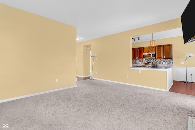 15329 Smithfield Dr, Westfield, IN 46074 - unfurnished living room featuring dark colored carpet, a sink, and baseboards