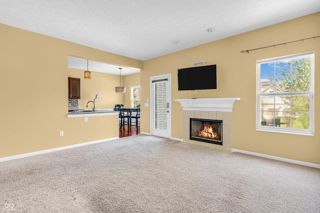 15329 Smithfield Dr, Westfield, IN 46074 - unfurnished living room featuring a fireplace, baseboards, plenty of natural light, and light carpet