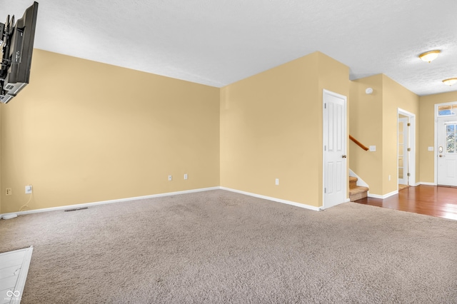 15329 Smithfield Dr, Westfield, IN 46074 - unfurnished living room with carpet flooring, a textured ceiling, stairs, baseboards, and visible vents