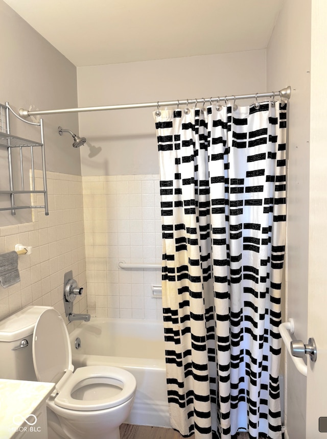 full bathroom with shower / bath combo with shower curtain, toilet, and tile walls