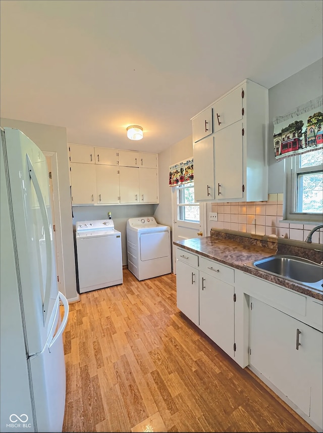 laundry room with a sink, light wood-type flooring, and independent washer and dryer