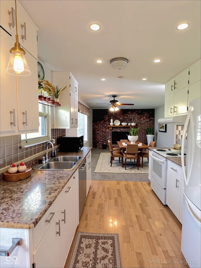 kitchen featuring a sink, a ceiling fan, white appliances, and light wood-style flooring