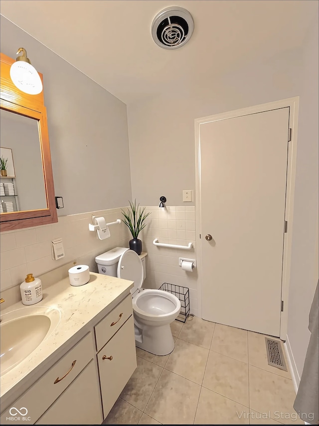 bathroom with tile patterned flooring, vanity, visible vents, and tile walls