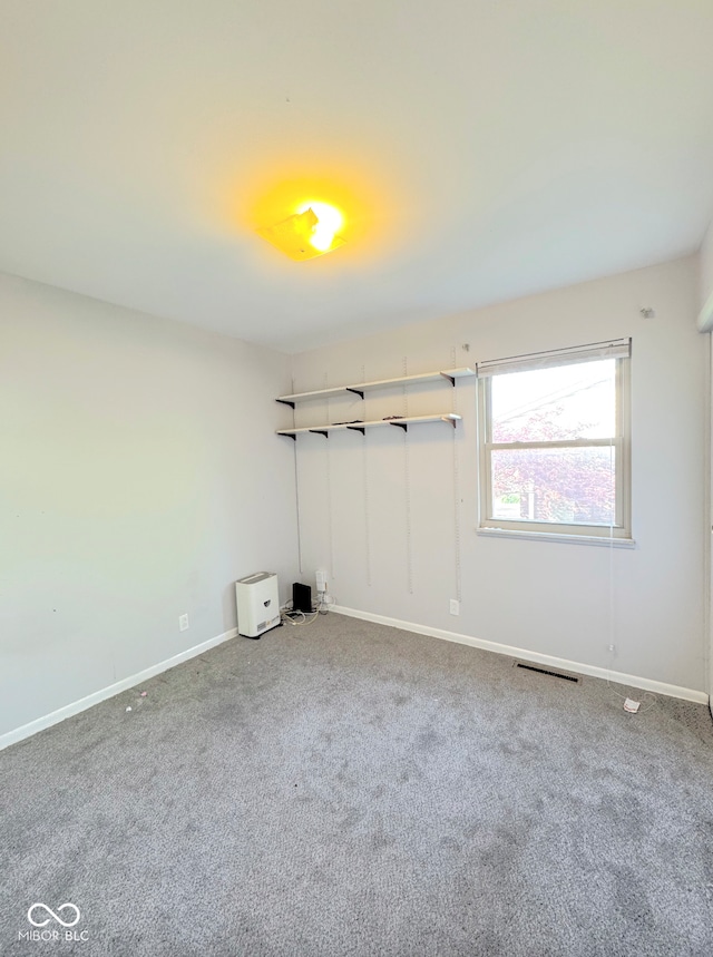 unfurnished bedroom featuring baseboards, carpet flooring, and visible vents