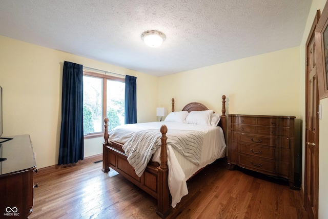 bedroom featuring a textured ceiling and wood finished floors