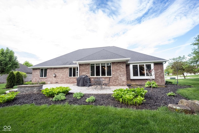 back of house with a lawn, a patio area, brick siding, and a shingled roof