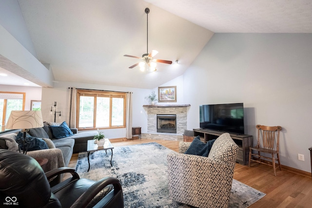 living area with a fireplace, ceiling fan, a healthy amount of sunlight, and wood finished floors