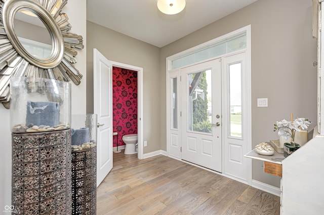 foyer entrance featuring baseboards and light wood finished floors
