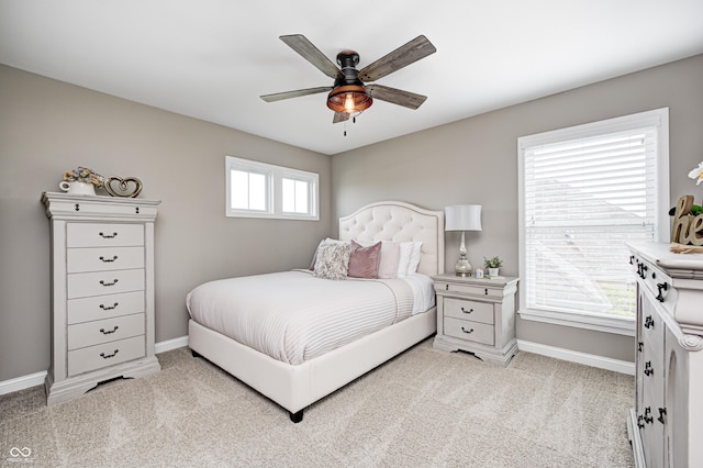 bedroom with baseboards, a ceiling fan, and light colored carpet