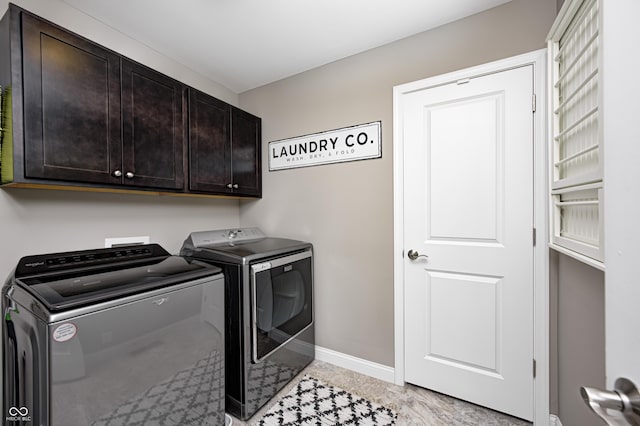 laundry room with baseboards, cabinet space, and washing machine and clothes dryer