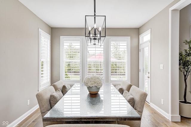 dining area with an inviting chandelier, light wood finished floors, and a healthy amount of sunlight