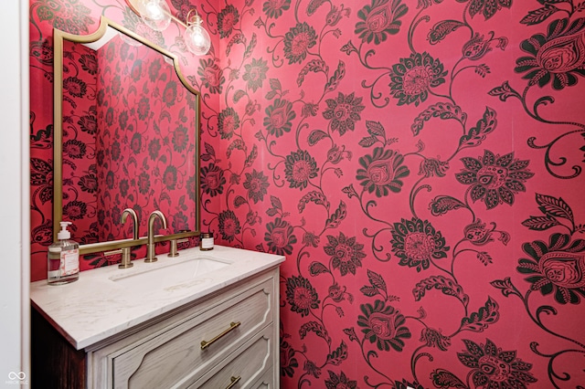 bathroom featuring vanity and wallpapered walls