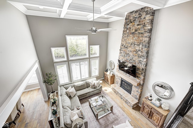living area with plenty of natural light, coffered ceiling, light wood-type flooring, and beam ceiling