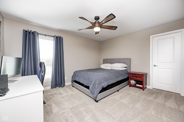 bedroom with light colored carpet, a ceiling fan, and baseboards
