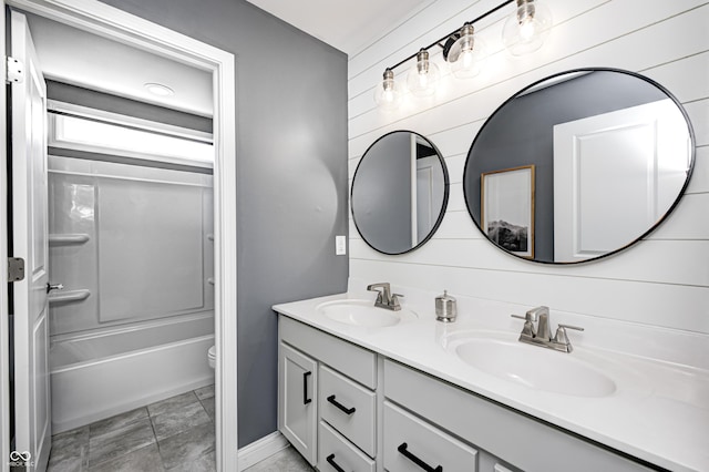 bathroom with double vanity, a sink, baseboards, and toilet