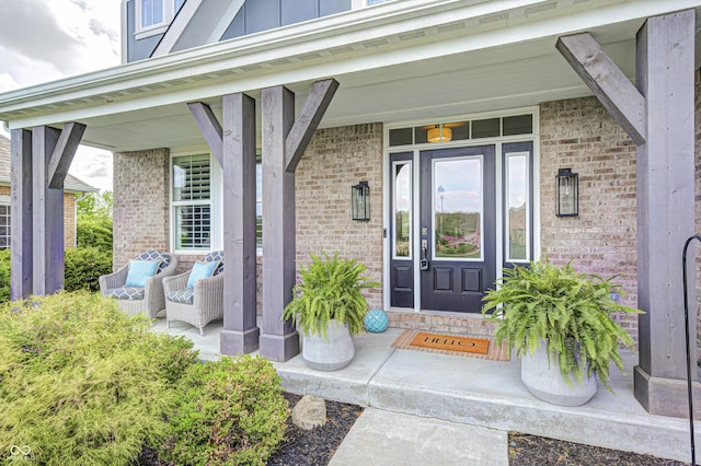 property entrance with covered porch, brick siding, and board and batten siding