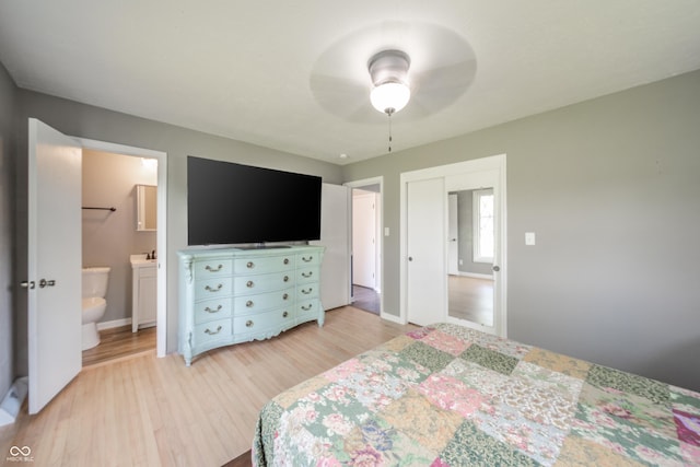 bedroom with baseboards, ceiling fan, ensuite bathroom, and light wood finished floors
