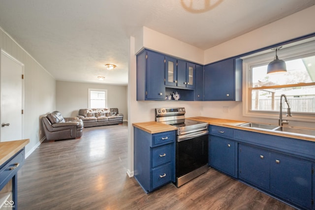 kitchen featuring blue cabinetry, wooden counters, a sink, and stainless steel range with electric stovetop