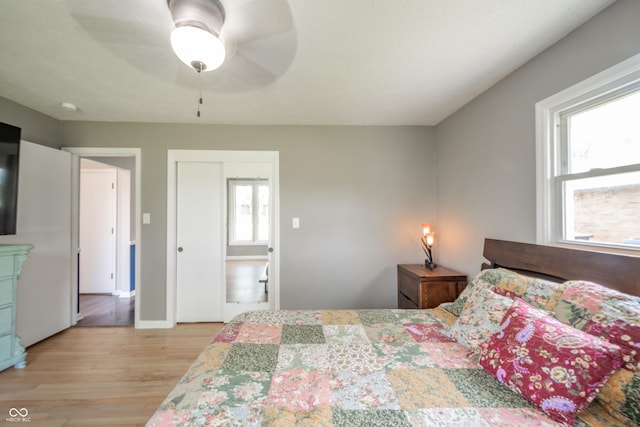 bedroom featuring ceiling fan, baseboards, and light wood-style floors