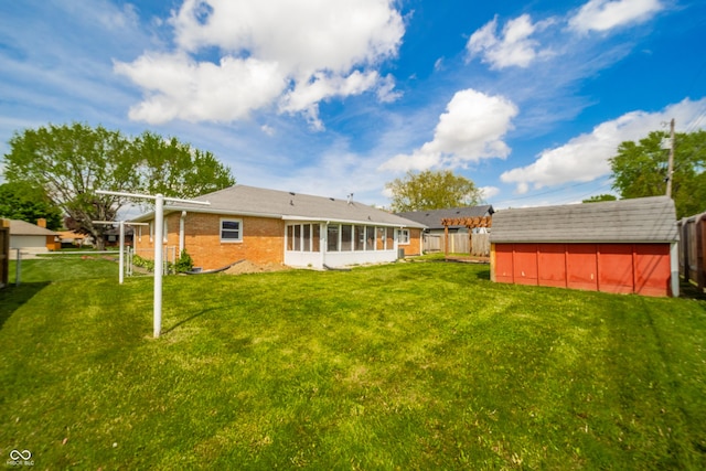 rear view of house with brick siding, an outbuilding, a fenced backyard, and a storage unit