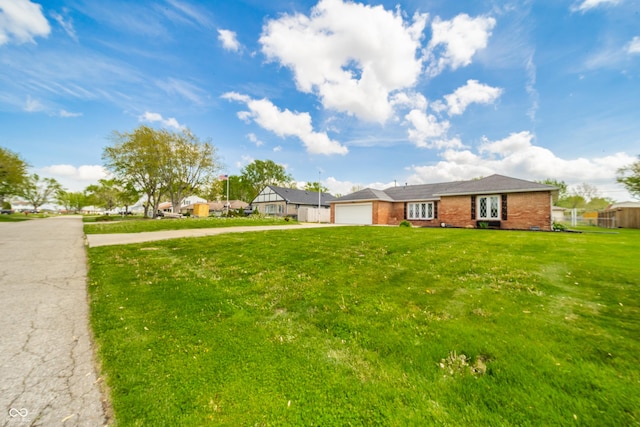 view of yard with an attached garage and driveway