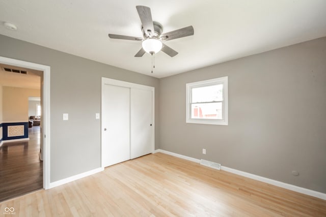 unfurnished bedroom featuring visible vents, baseboards, a closet, and light wood-type flooring