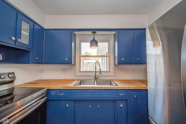 kitchen featuring blue cabinets, a sink, and appliances with stainless steel finishes