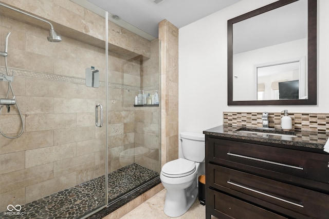 bathroom featuring vanity, decorative backsplash, a shower stall, and toilet