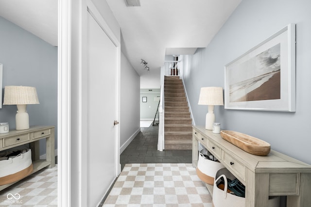 hall with baseboards and stairs