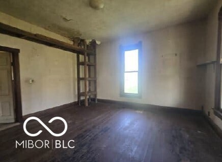 unfurnished room featuring baseboards and wood finished floors