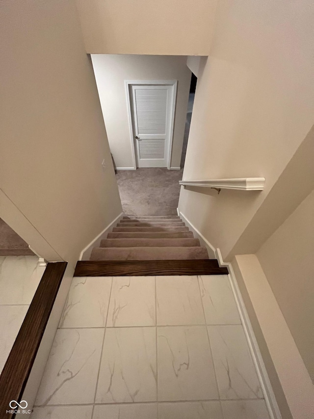 staircase with baseboards and marble finish floor