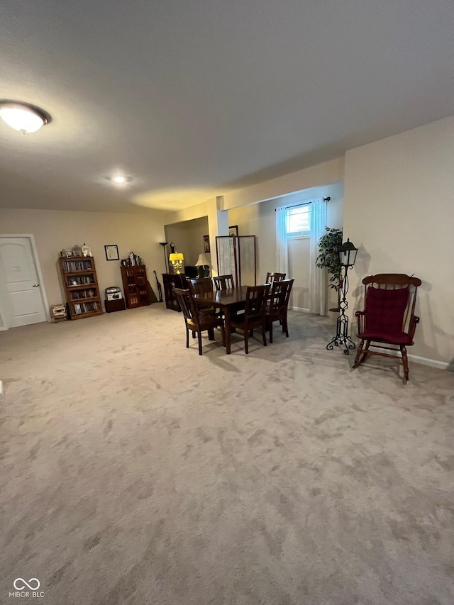 carpeted dining room featuring baseboards