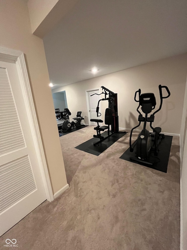 workout area featuring baseboards and carpet