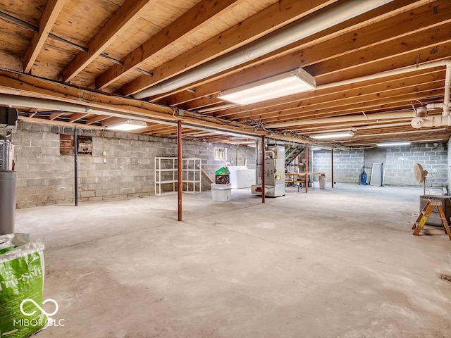 unfinished below grade area with heating unit, stairs, and washing machine and dryer