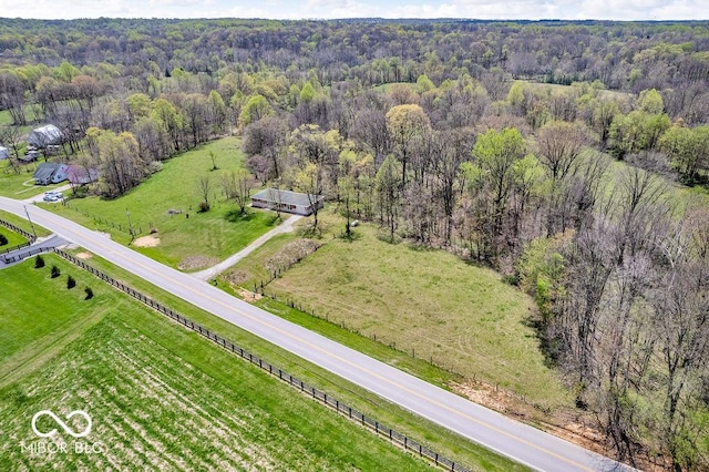drone / aerial view featuring a rural view and a wooded view