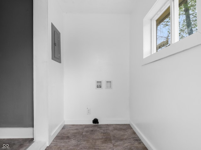 washroom featuring baseboards, hookup for a washing machine, and electric panel