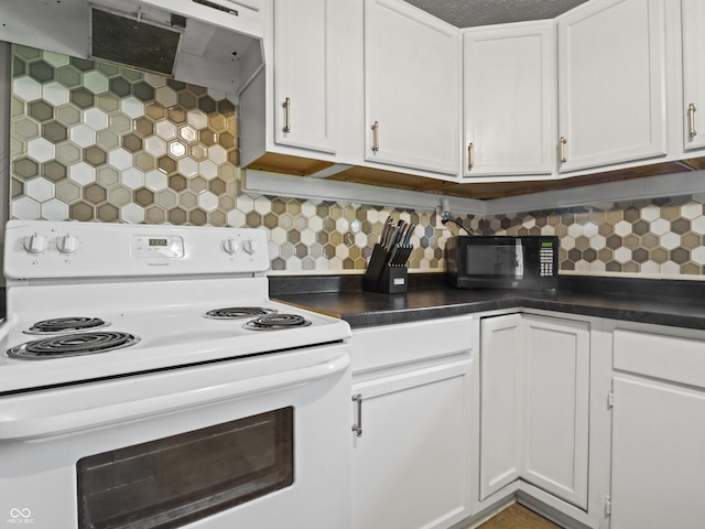 1401 E 24th St, Muncie, IN 47302 - kitchen featuring white range with electric stovetop, black microwave, ventilation hood, dark countertops, and white cabinetry