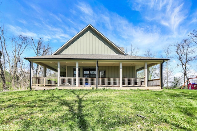 back of property with a shingled roof, board and batten siding, and a yard