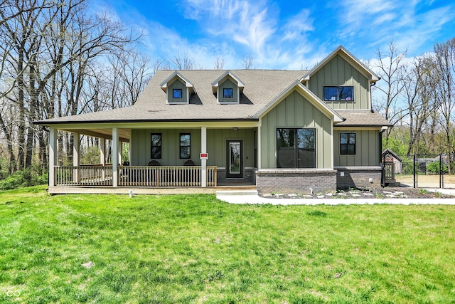 view of front of property with covered porch, board and batten siding, and a front yard