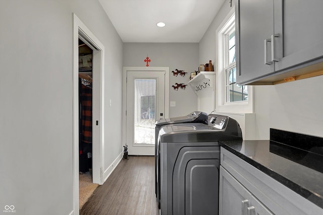 laundry room featuring independent washer and dryer, cabinet space, recessed lighting, baseboards, and dark wood-type flooring