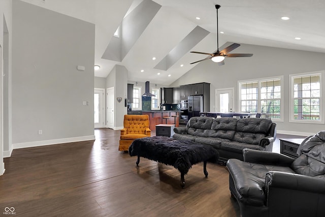 living area featuring baseboards, a ceiling fan, dark wood-style floors, and high vaulted ceiling