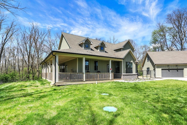 farmhouse inspired home with board and batten siding, covered porch, roof with shingles, a front yard, and a garage