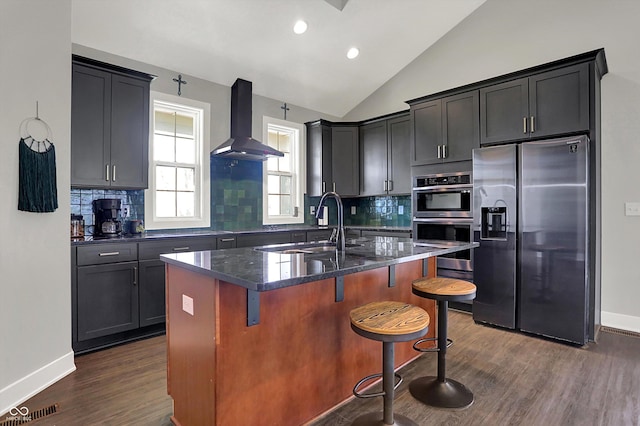 kitchen with decorative backsplash, range hood, dark wood-type flooring, a sink, and stainless steel appliances