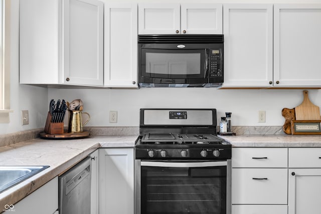 kitchen featuring a sink, light countertops, white cabinetry, and appliances with stainless steel finishes