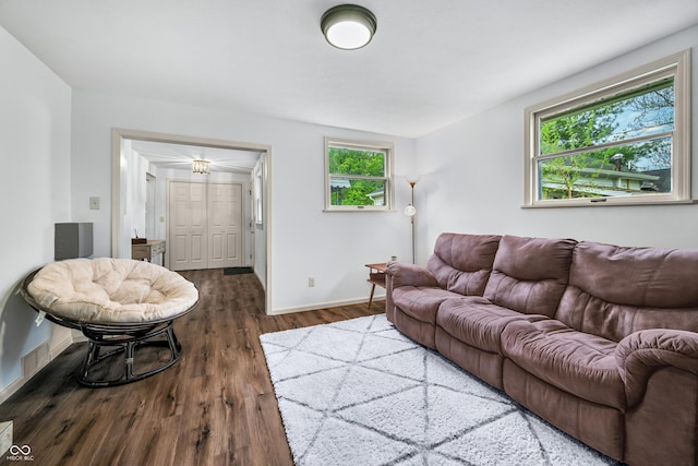 living area featuring baseboards, visible vents, and wood finished floors