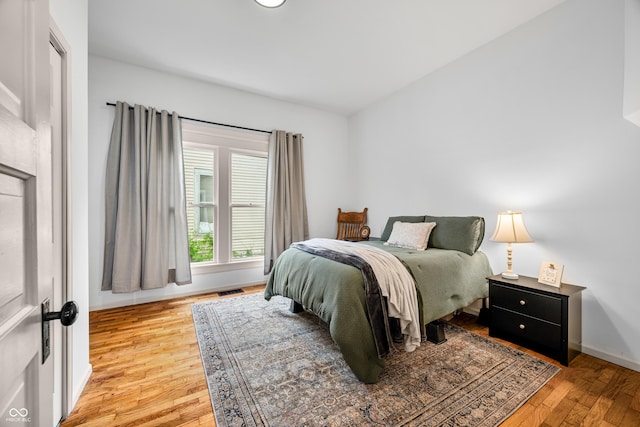 bedroom with light wood-style floors, baseboards, and visible vents